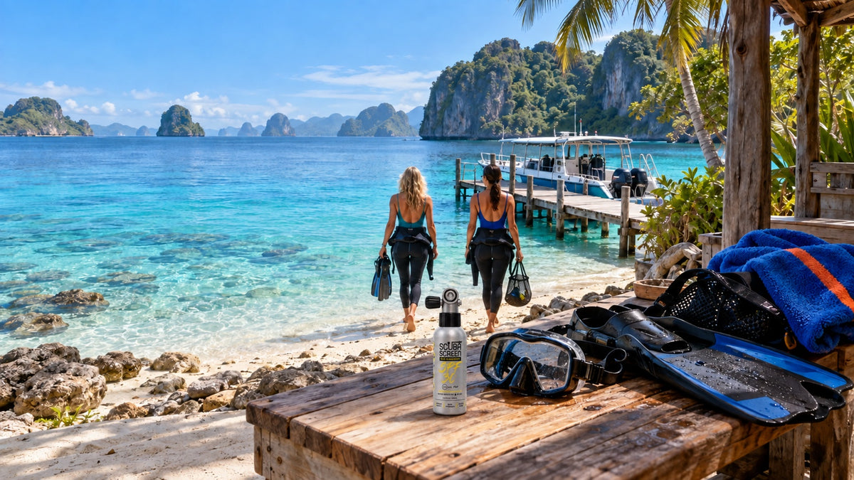 Two divers walking toward a tropical dive boat with ScubaScreen sunscreen and dive gear in the foreground